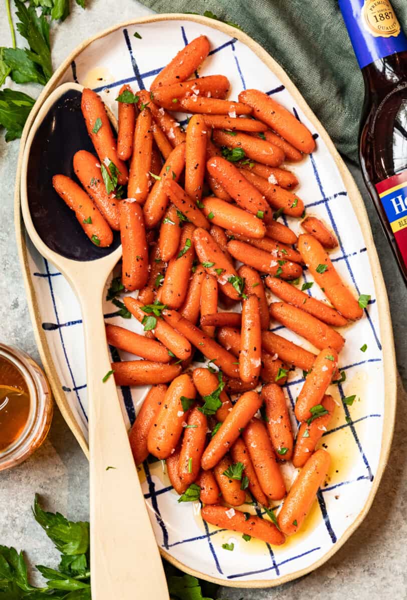 red wine glazed carrots in a serving dish with a serving spoon