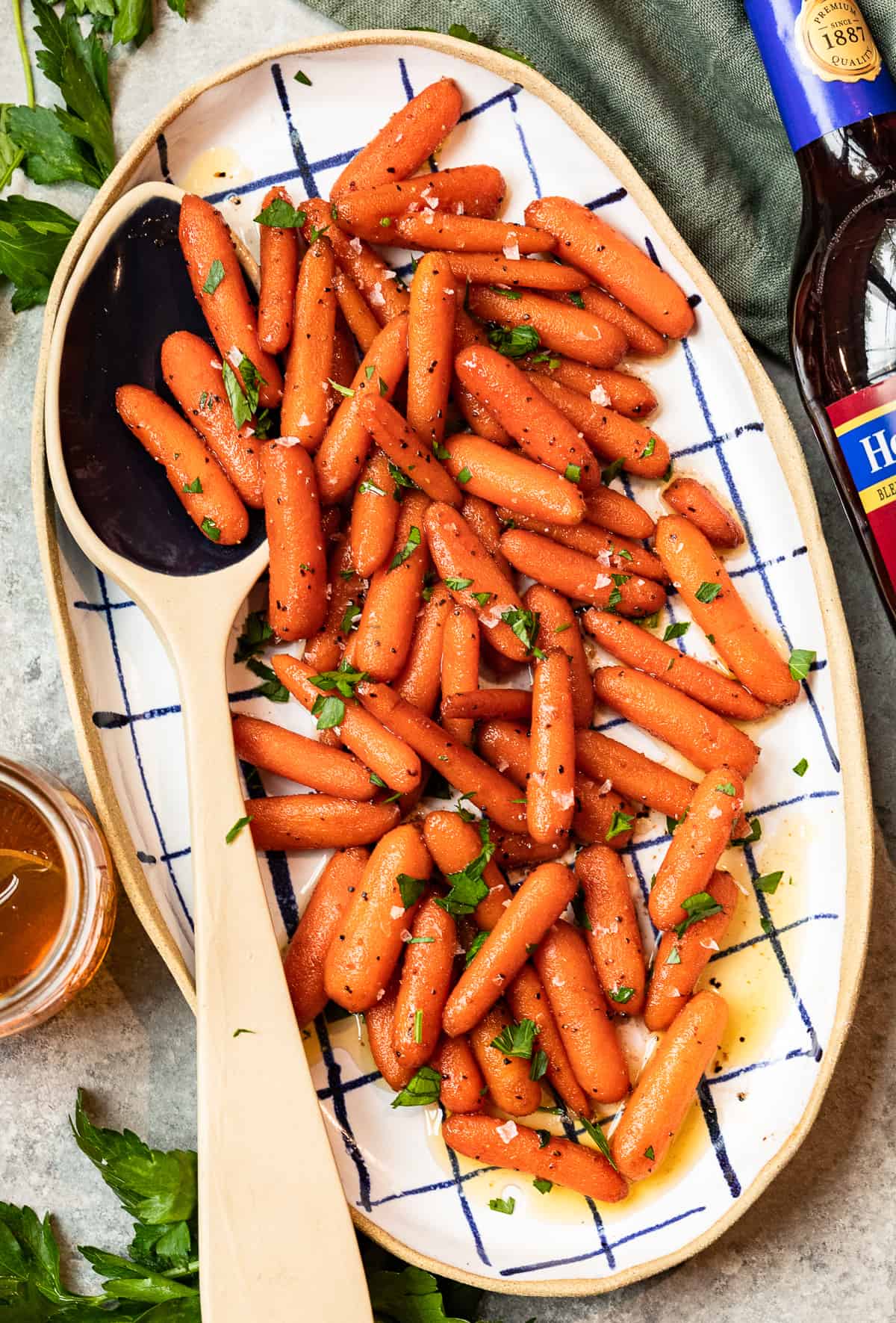 red wine glazed carrots in a serving dish with a serving spoon