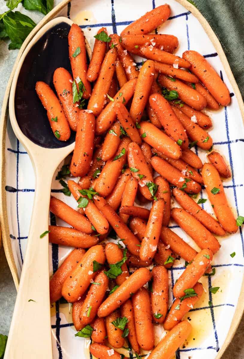 red wine glazed carrots in a serving dish with a serving spoon