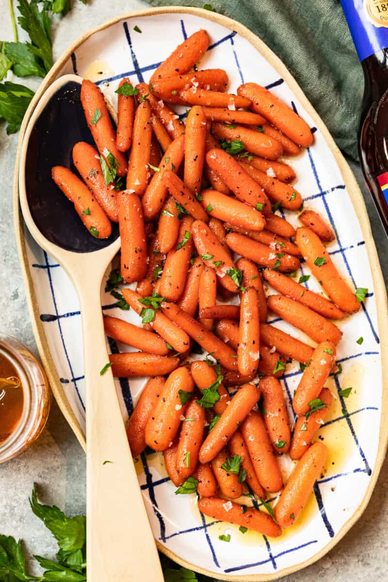 red wine glazed carrots in a serving dish with a serving spoon