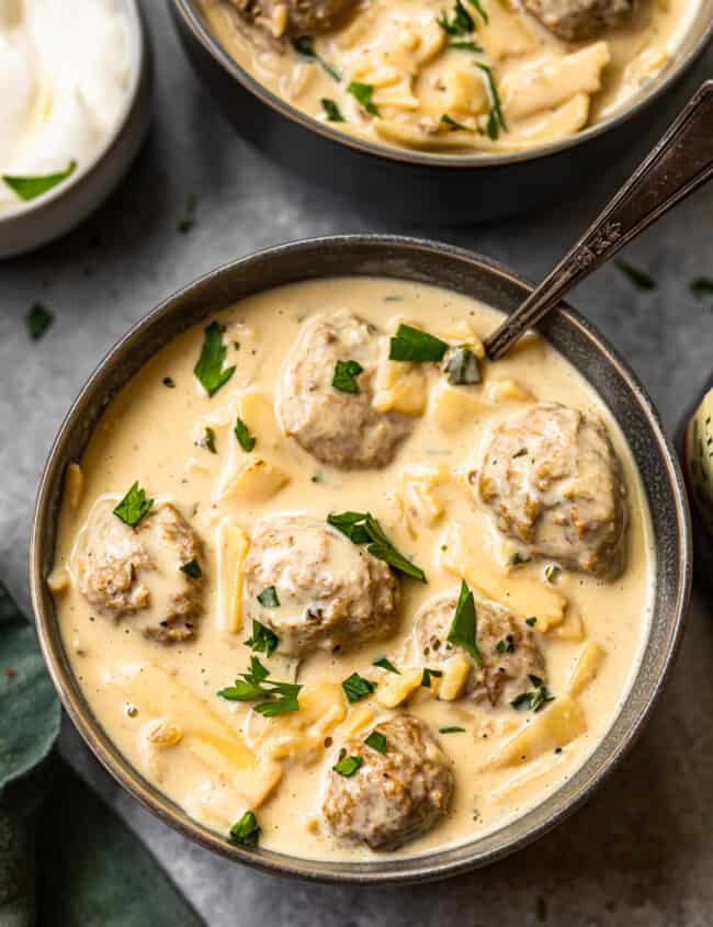 swedish meatball soup in a black bowl with a spoon