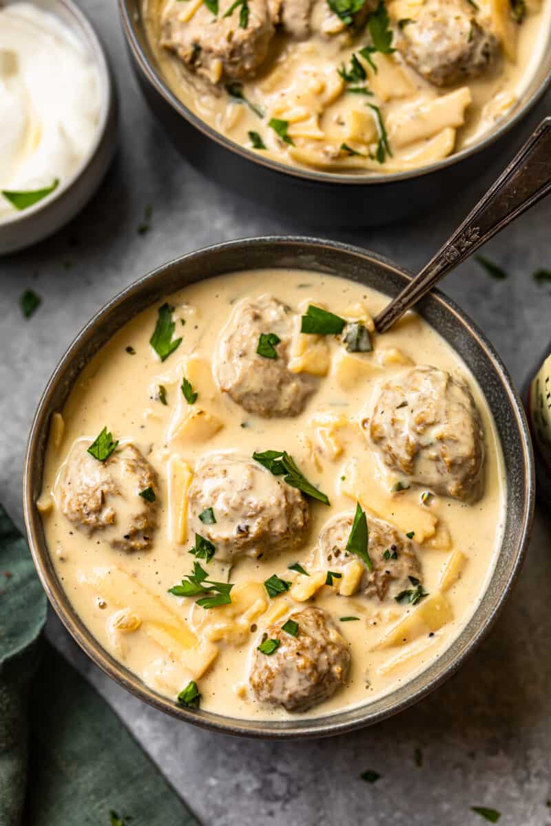 swedish meatball soup in a black bowl with a spoon