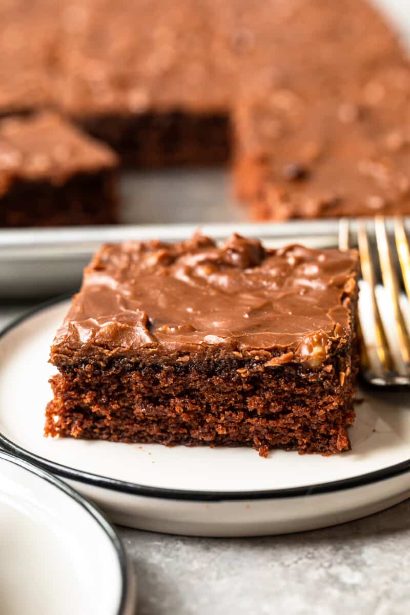 piece of texas sheet cake on a white plate with a fork