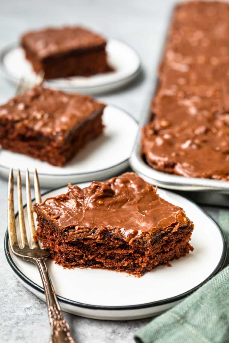 pieces of texas sheet cake on white plates with forks