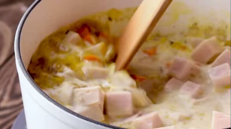 cubes of turkey being stirred into a soup