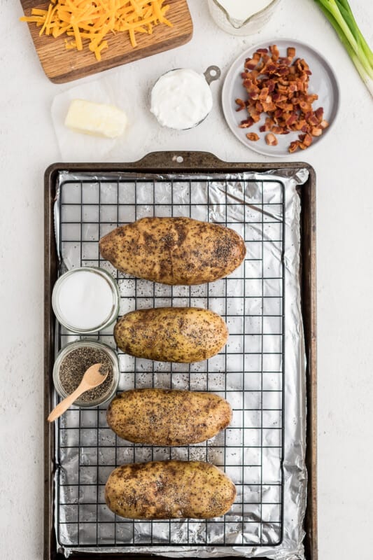 4 baked potatoes on a cooling rack