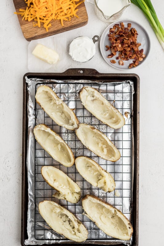 8 baked potato skins on a cooling rack before filling