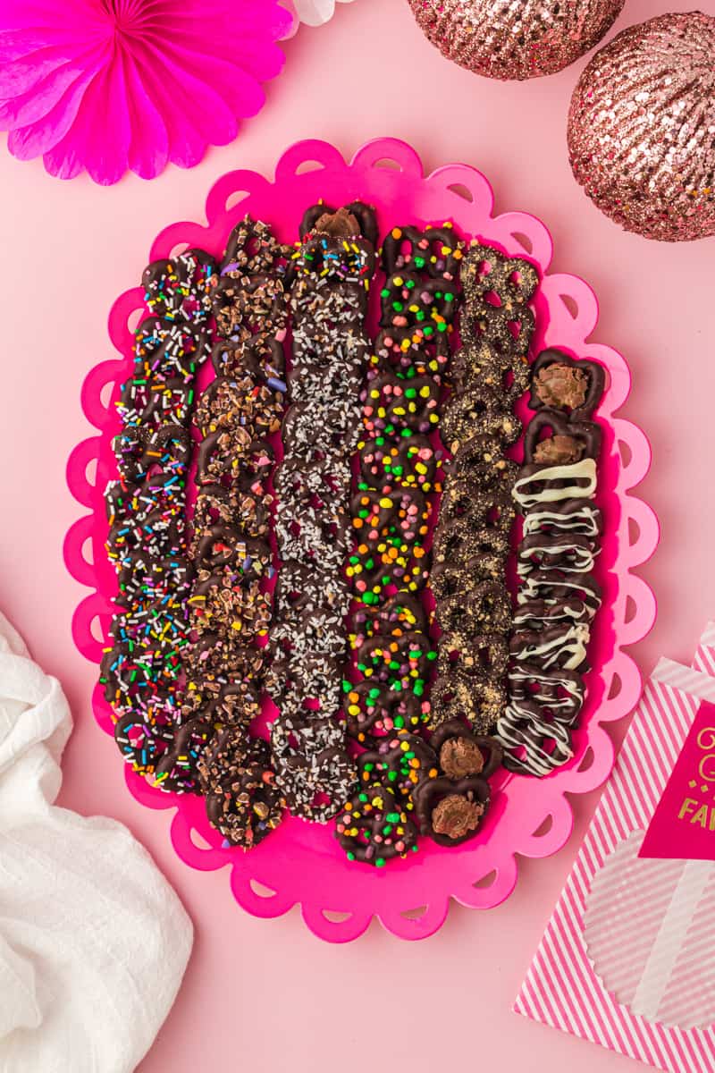 overhead image of chocolate covered pretzels on a pink serving tray