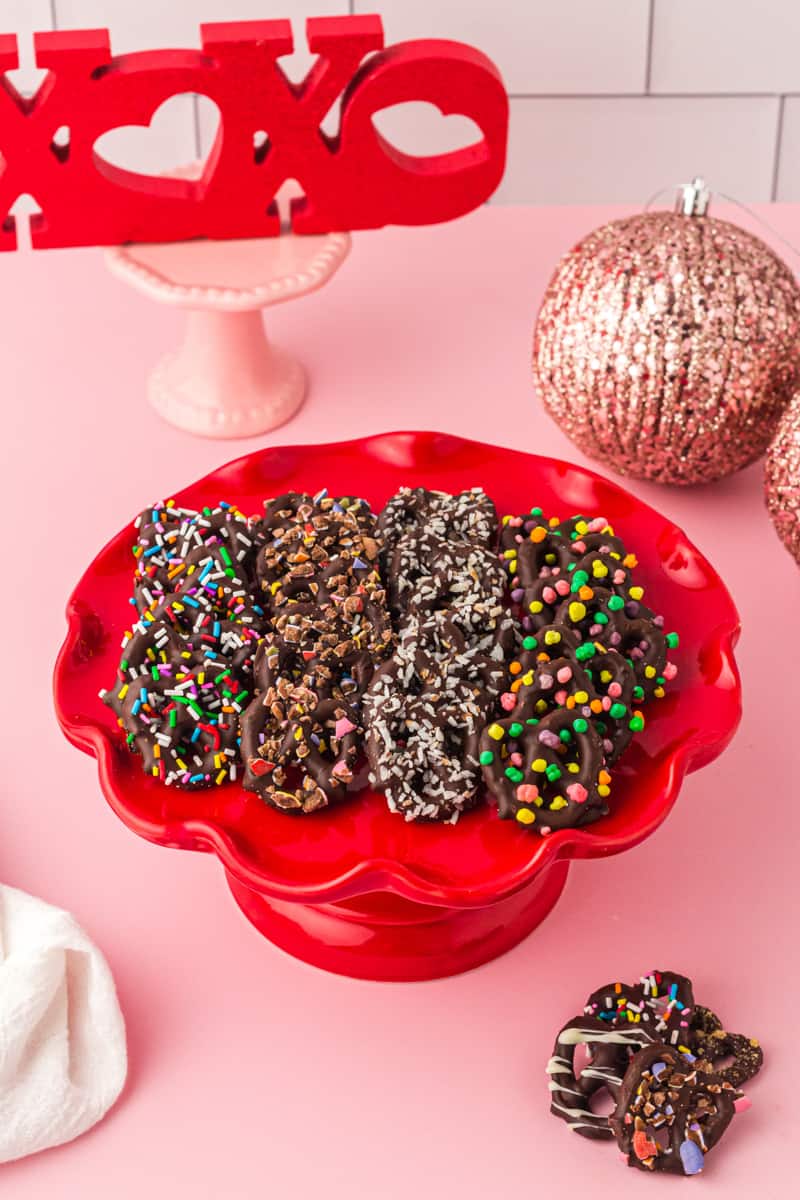 chocolate covered pretzels on a red cake stand
