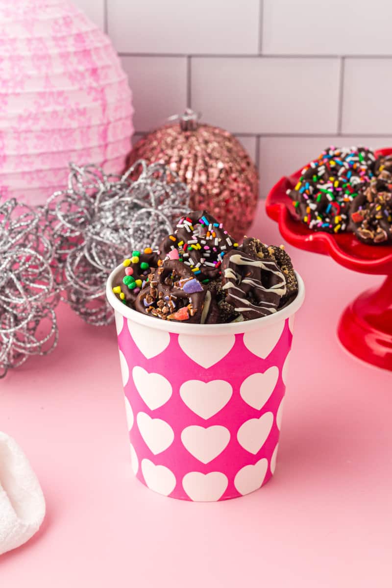 chocolate covered pretzels in a pink and white container