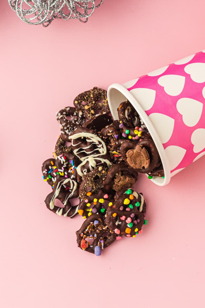 chocolate covered pretzels coming out of a pink and white container