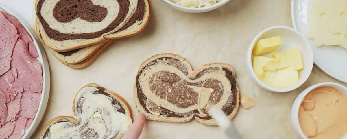 Spreading Thousand Island dressing over the marbled rye. 