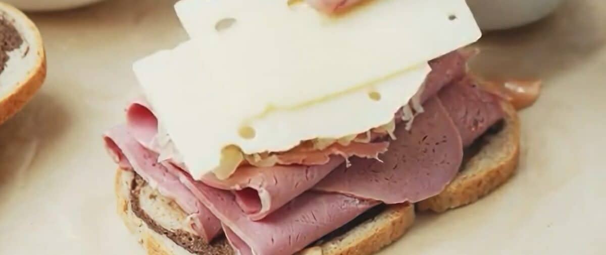 Layering the bread with corned beef, sauerkraut, and Swiss cheese. 