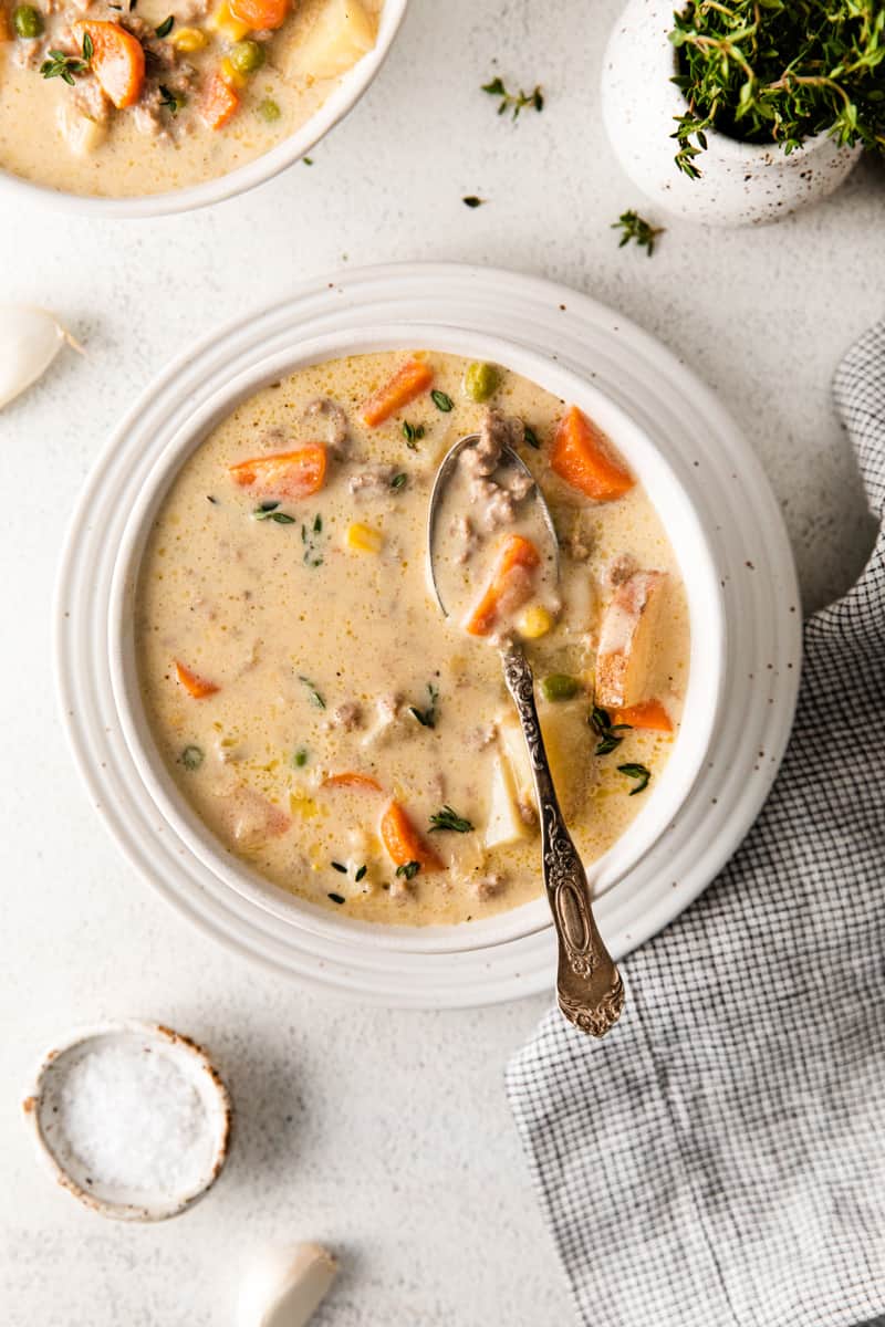 overhead image of shepherd's pie soup in a white bowl with a spoon