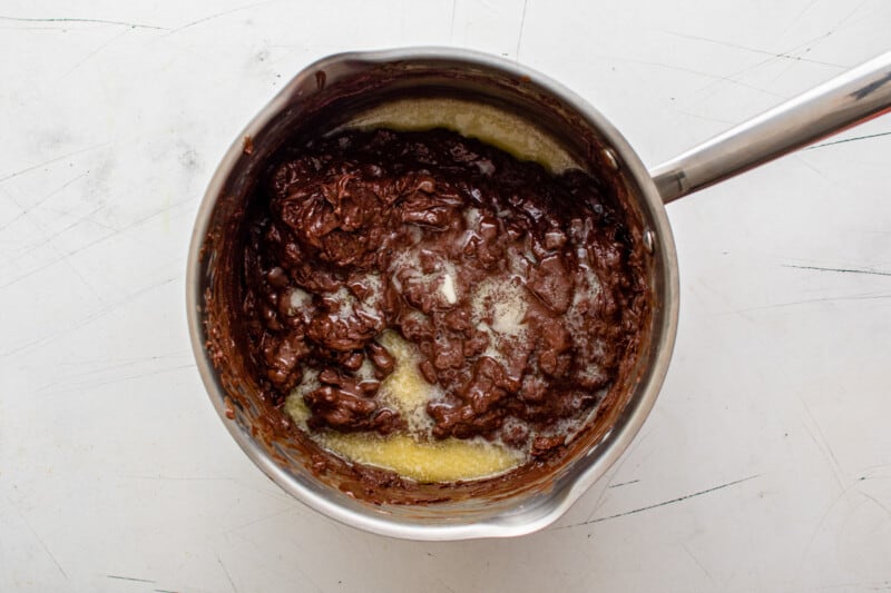 partially melted chocolate chips with butter and vanilla extract in a saucepan