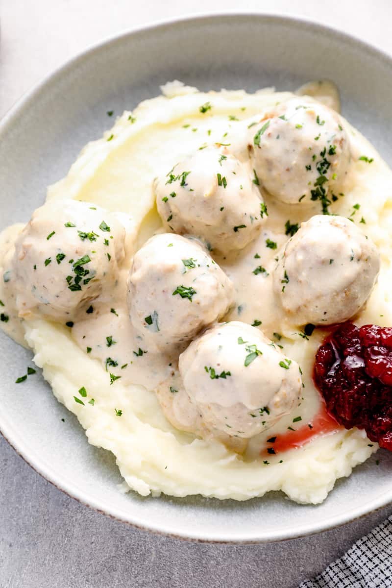 crockpot swedish meatballs on top of mashed potatoes in a bowl