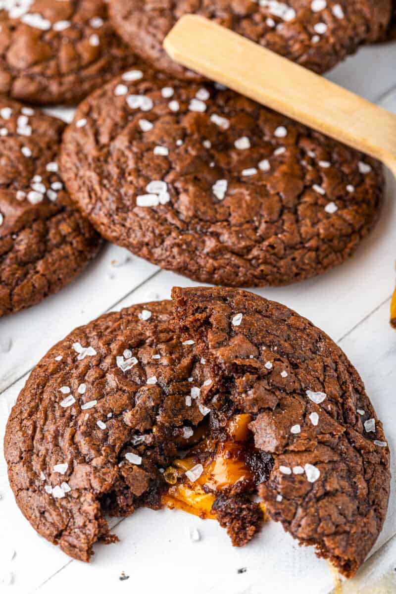 chocolate cookie broken in half showing the caramel center