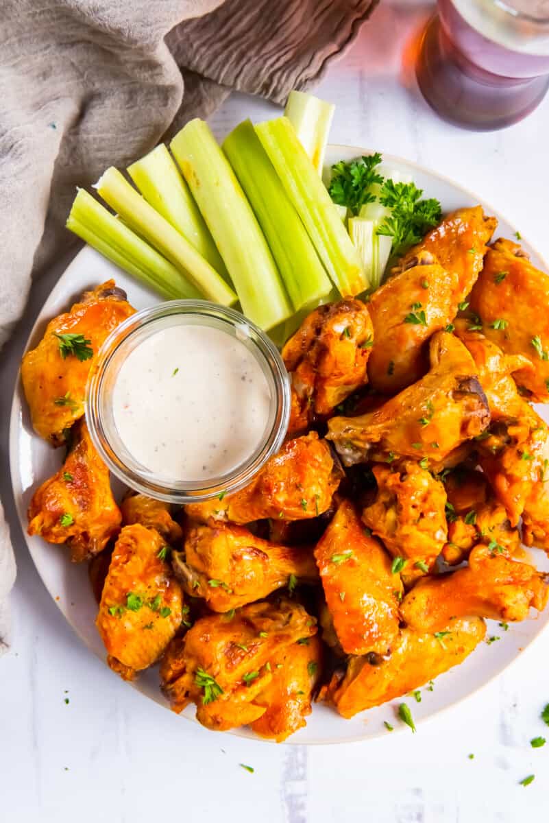 crockpot chicken wings on platter with buffalo sauce and ranch