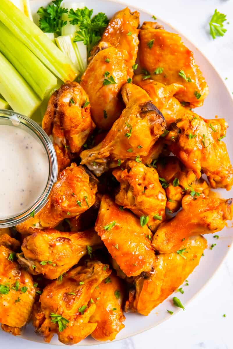 crockpot chicken wings on platter with buffalo sauce and ranch
