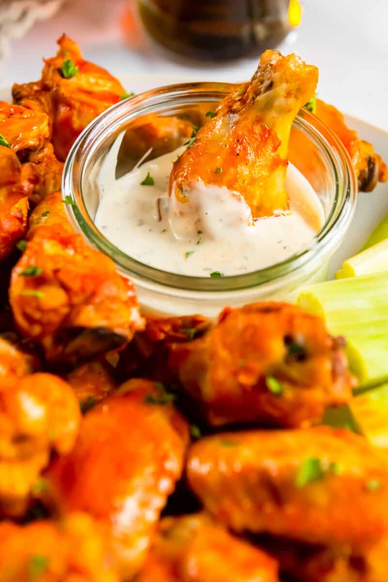 dipping crockpot chicken wing with buffalo sauce in ranch
