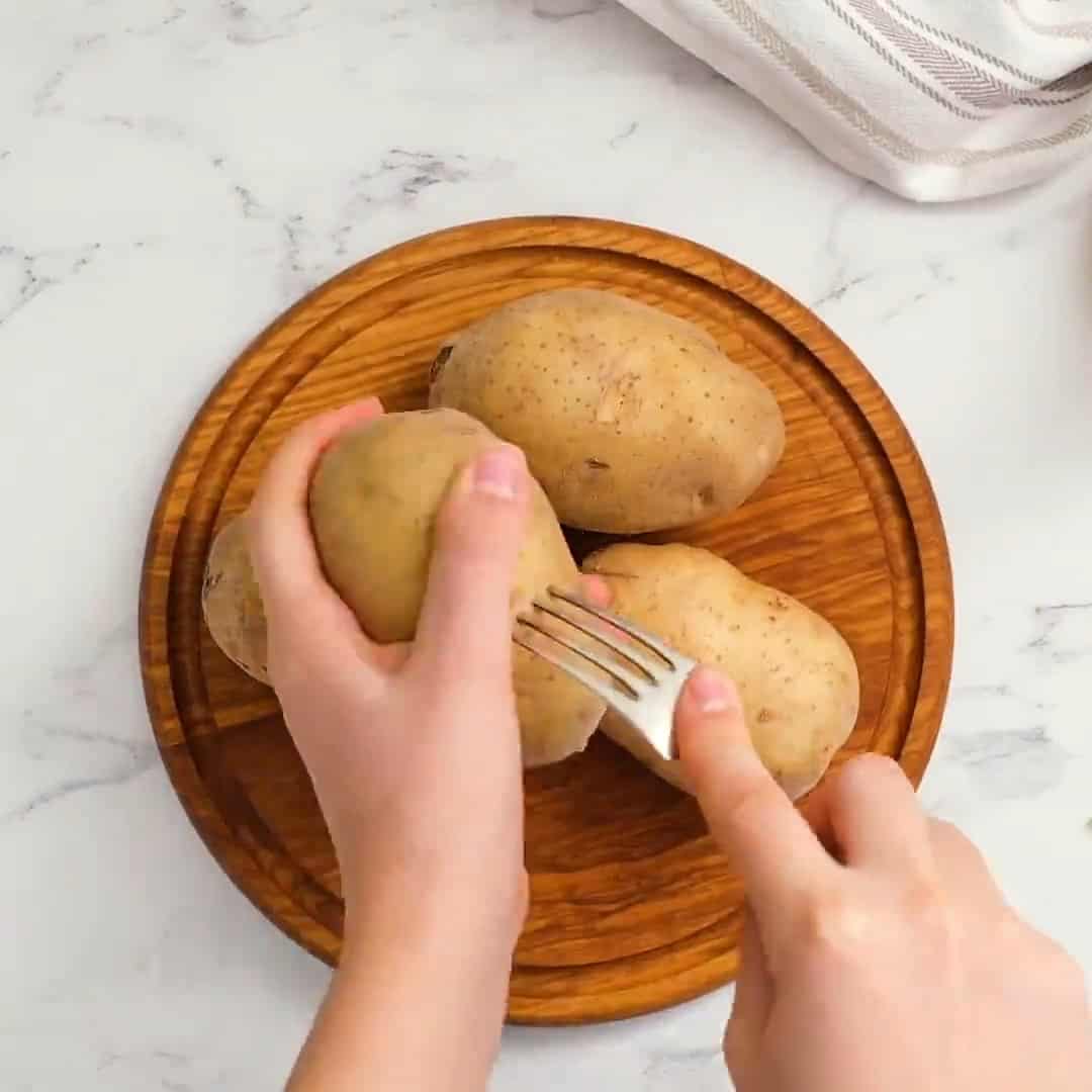 Piercing potatoes with a fork.