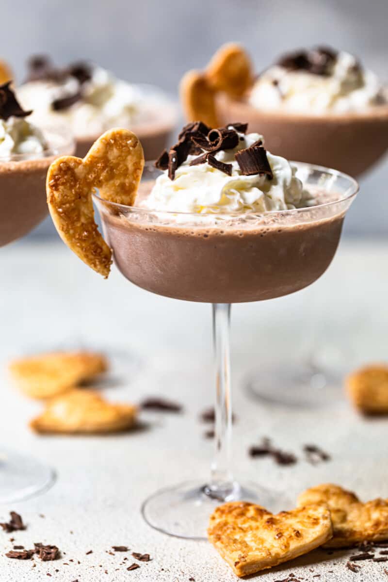 frozen french silk pie cocktail in a glass topped with whipped cream and chocolate shavings and garnished with baked pie crust cookie