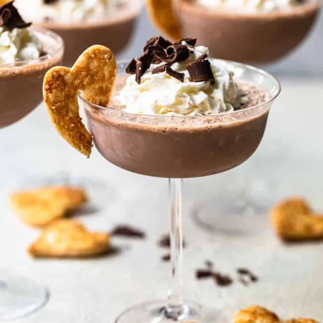 frozen french silk pie cocktails in glasses topped with whipped cream and chocolate shavings and garnished with baked pie crust cookies