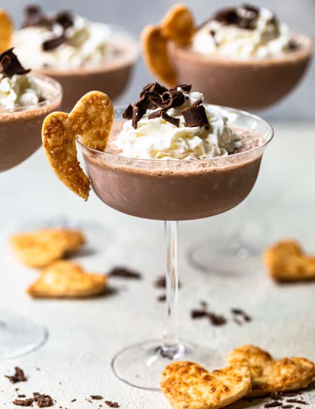 frozen french silk pie cocktails in glasses topped with whipped cream and chocolate shavings and garnished with baked pie crust cookies