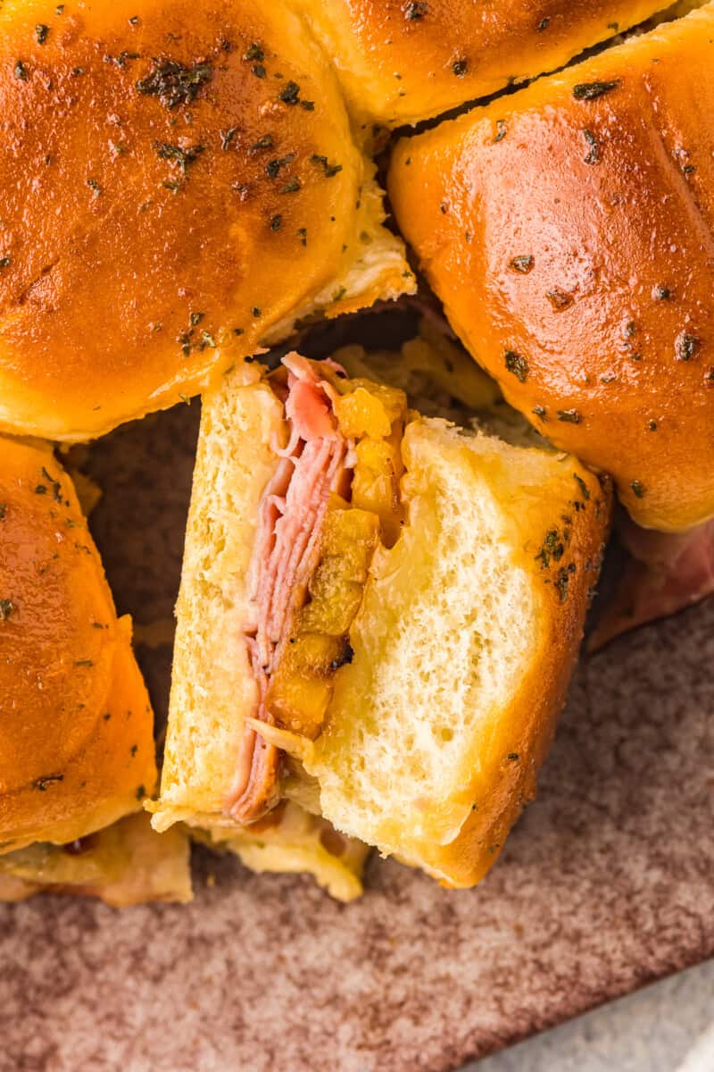 up close hawaiian ham and cheese sliders on a sheet pan