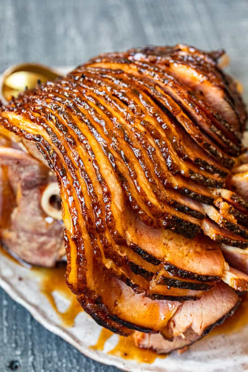 sliced honey baked ham on a white serving platter