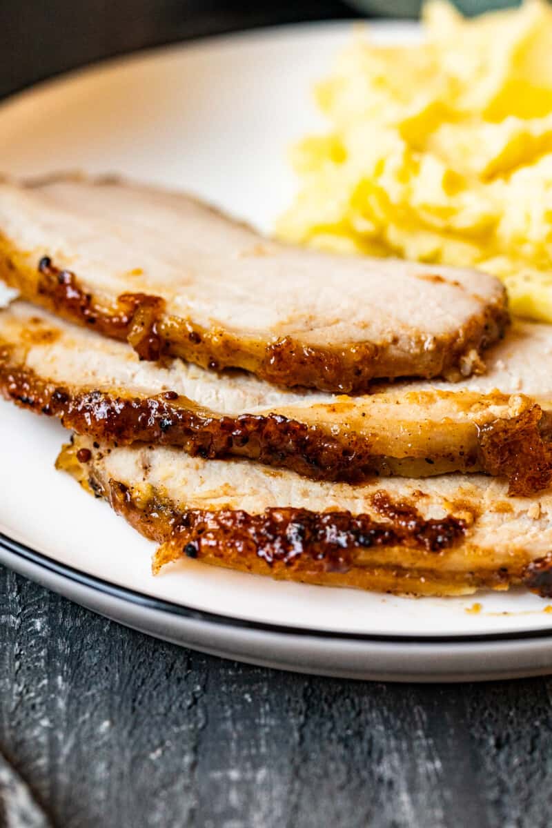 slices of honey baked pork tenderloin on a white dinner plate