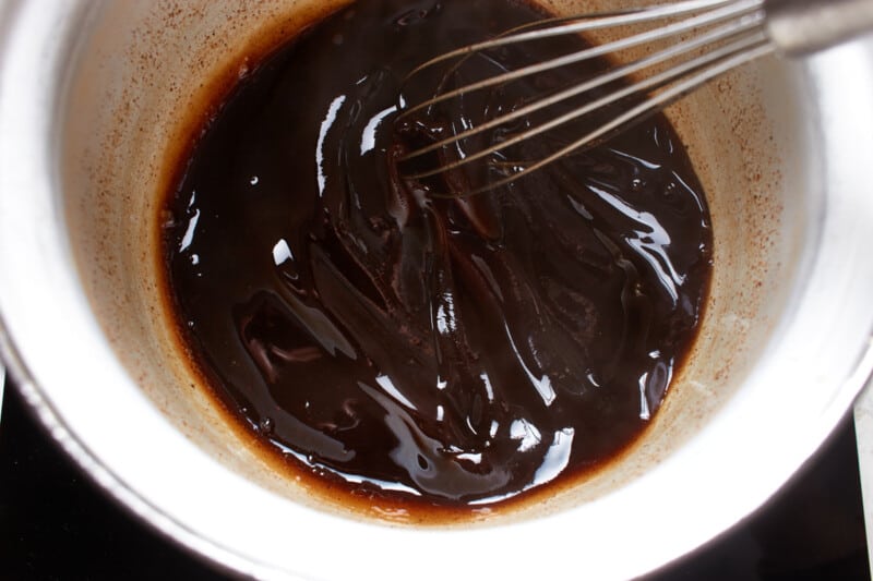 glaze for baked pork tenderloin in a white bowl with a whisk.