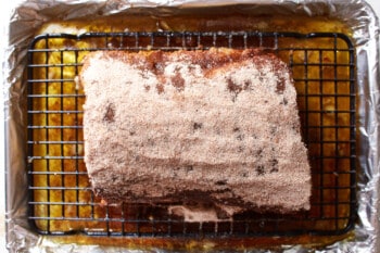 spice rub rubbed over pork tenderloin on a wire rack set in a rimmed baking sheet.