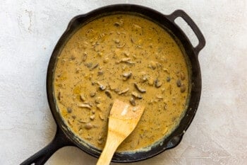 beef stroganoff sauce in a skillet with a wood spoon