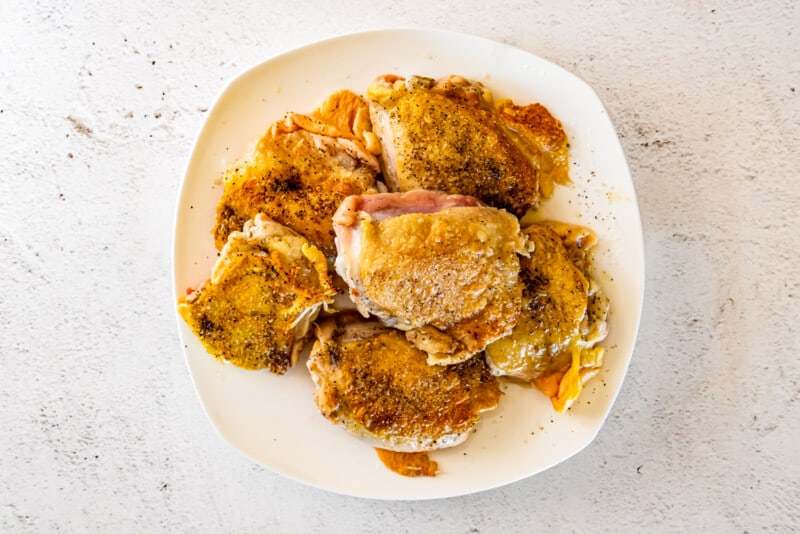 seared chicken thighs on a white plate