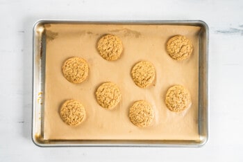 oatmeal cookies on a parchment paper lined baking sheet after baking