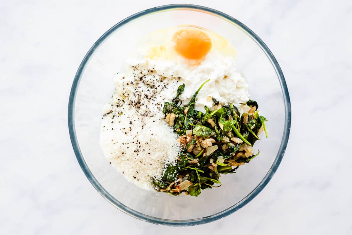 spinach and cheeses in a glass bowl.