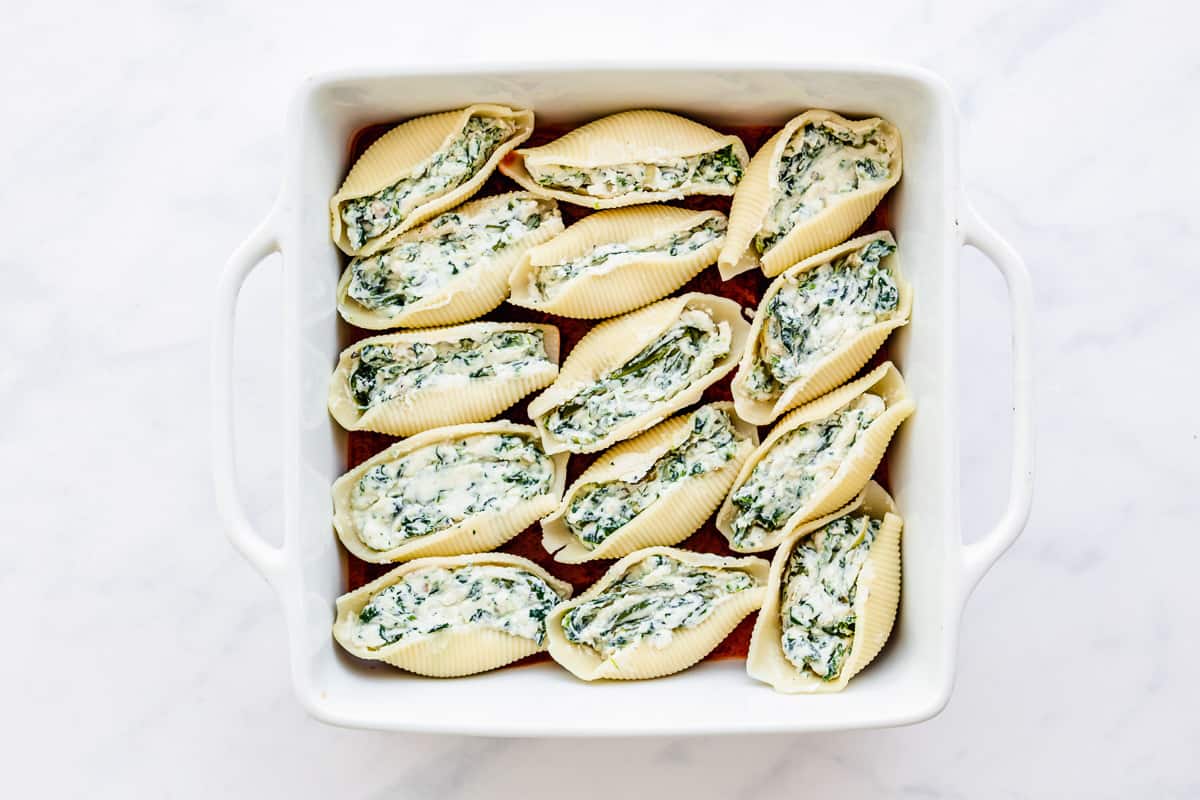 stuffed shells with spinach in a casserole dish.
