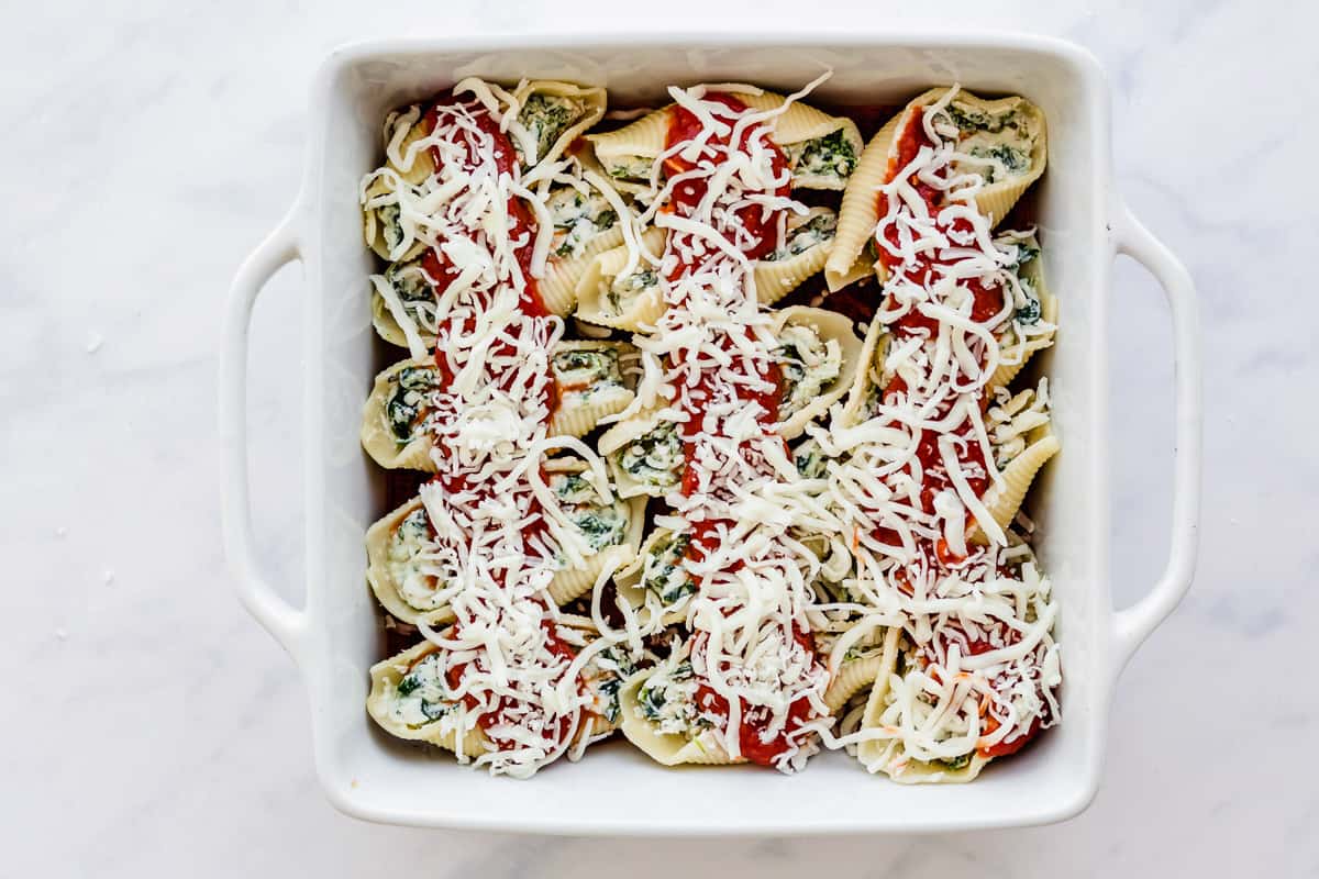 cheese topped stuffed shells in a casserole dish.