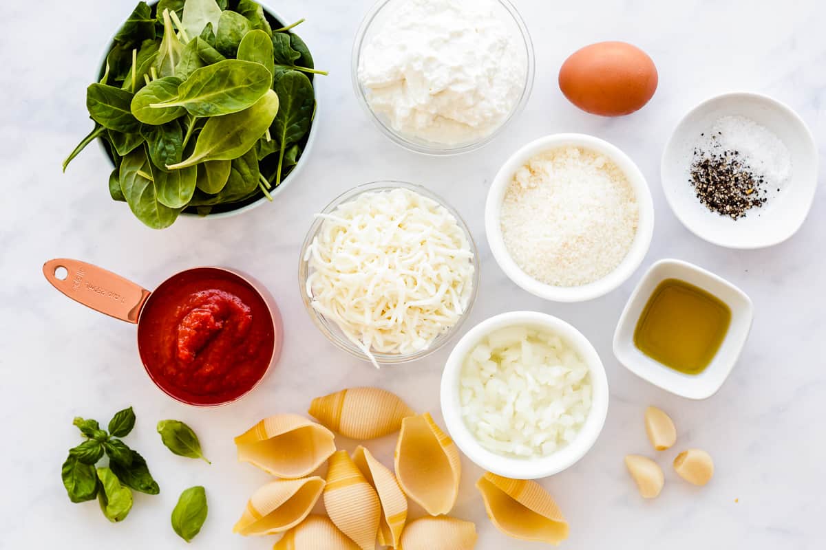 ingredients for stuffed shells with spinach in individual bowls.