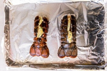 2 lobster tails on an aluminum foil lined baking sheet