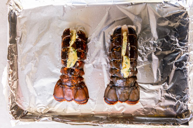 2 lobster tails on an aluminum foil lined baking sheet