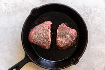 2 filet mignon in a skillet before cooking