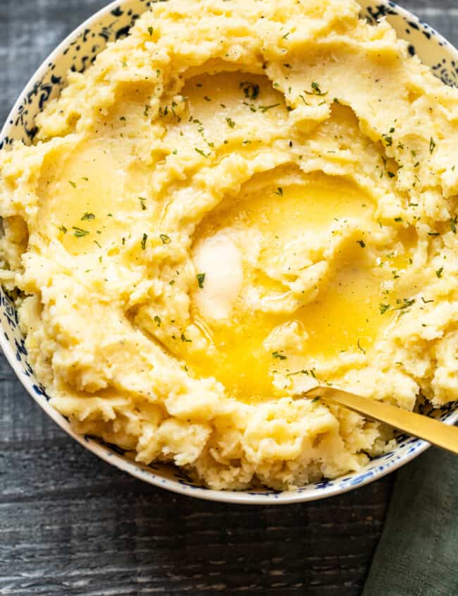 mashed potatoes in a bowl with butter on top with a spoon