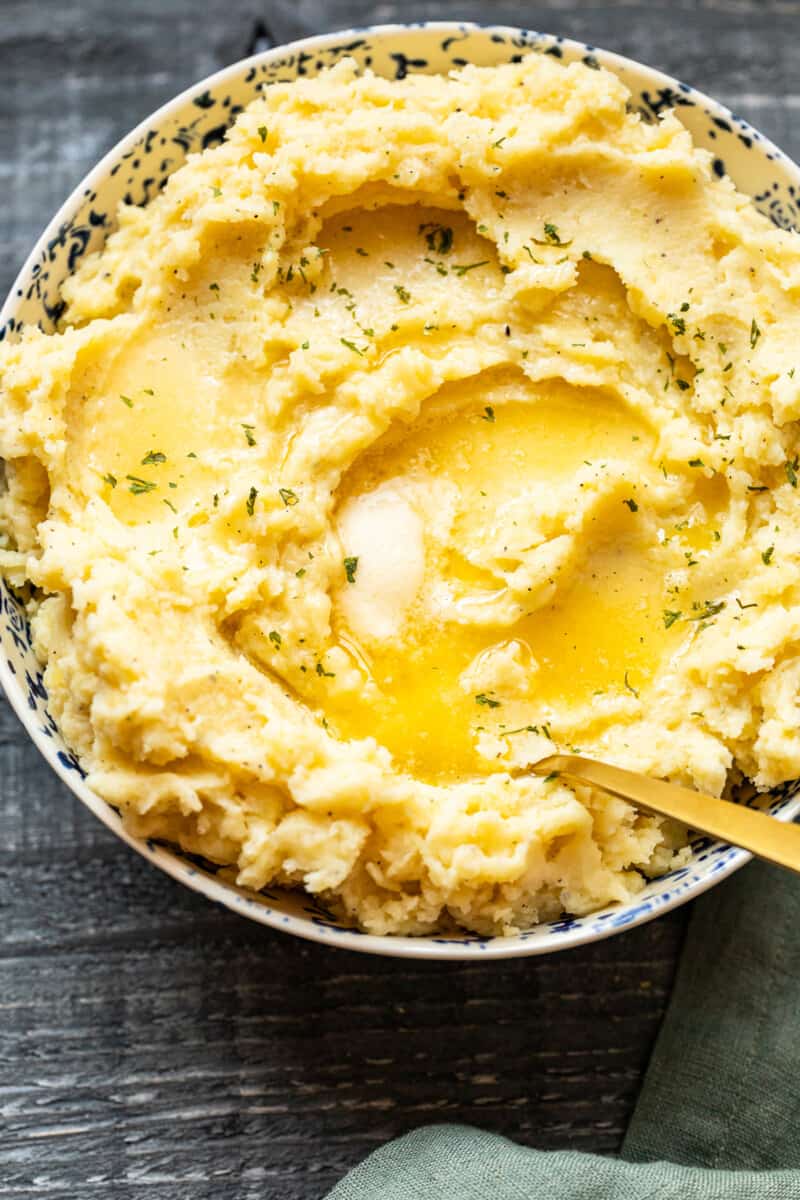 mashed potatoes in a bowl with butter on top with a spoon