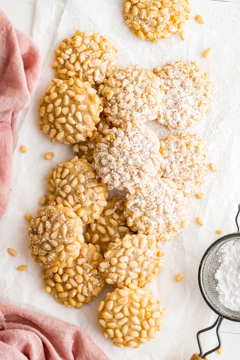 overhead image of pignoli cookies with a dusting of powdered sugar