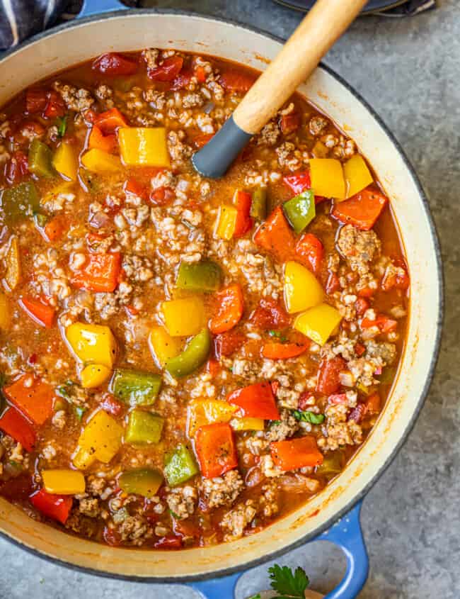 stuffed pepper soup in a blue dutch oven with a wood spoon