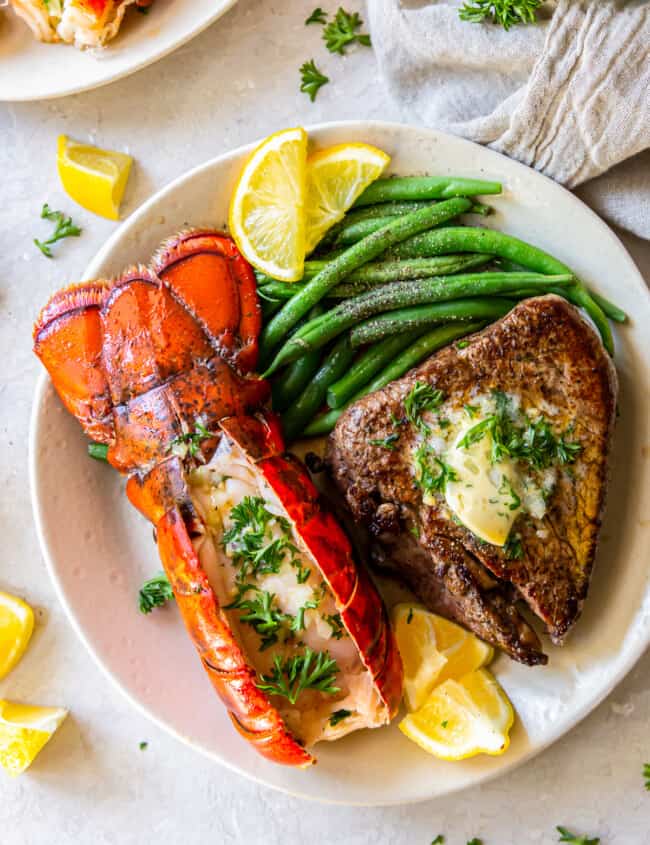 lobster tail and filet mignon with green beans on a plate