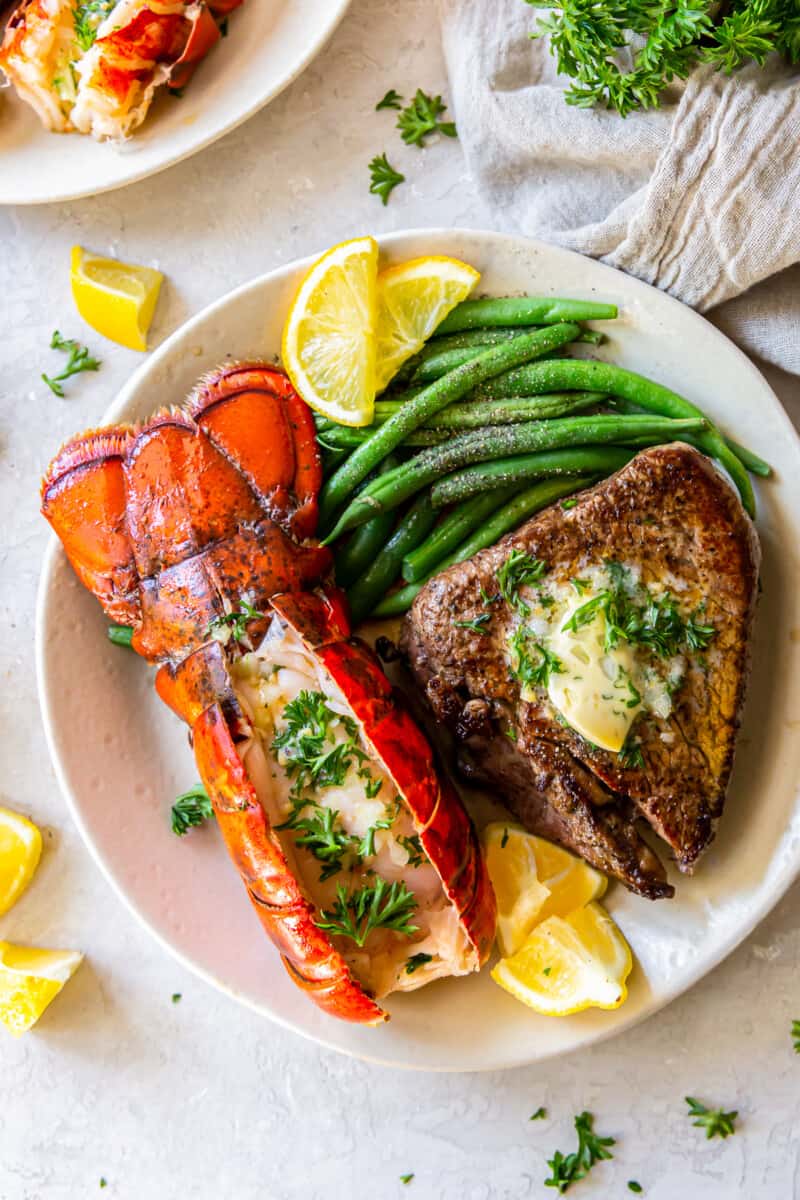 lobster tail and filet mignon with green beans on a plate