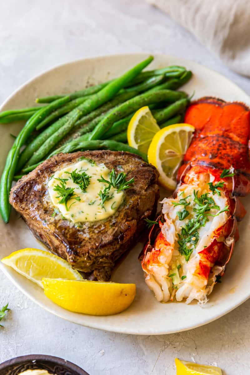 lobster tail and filet mignon with green beans on a plate